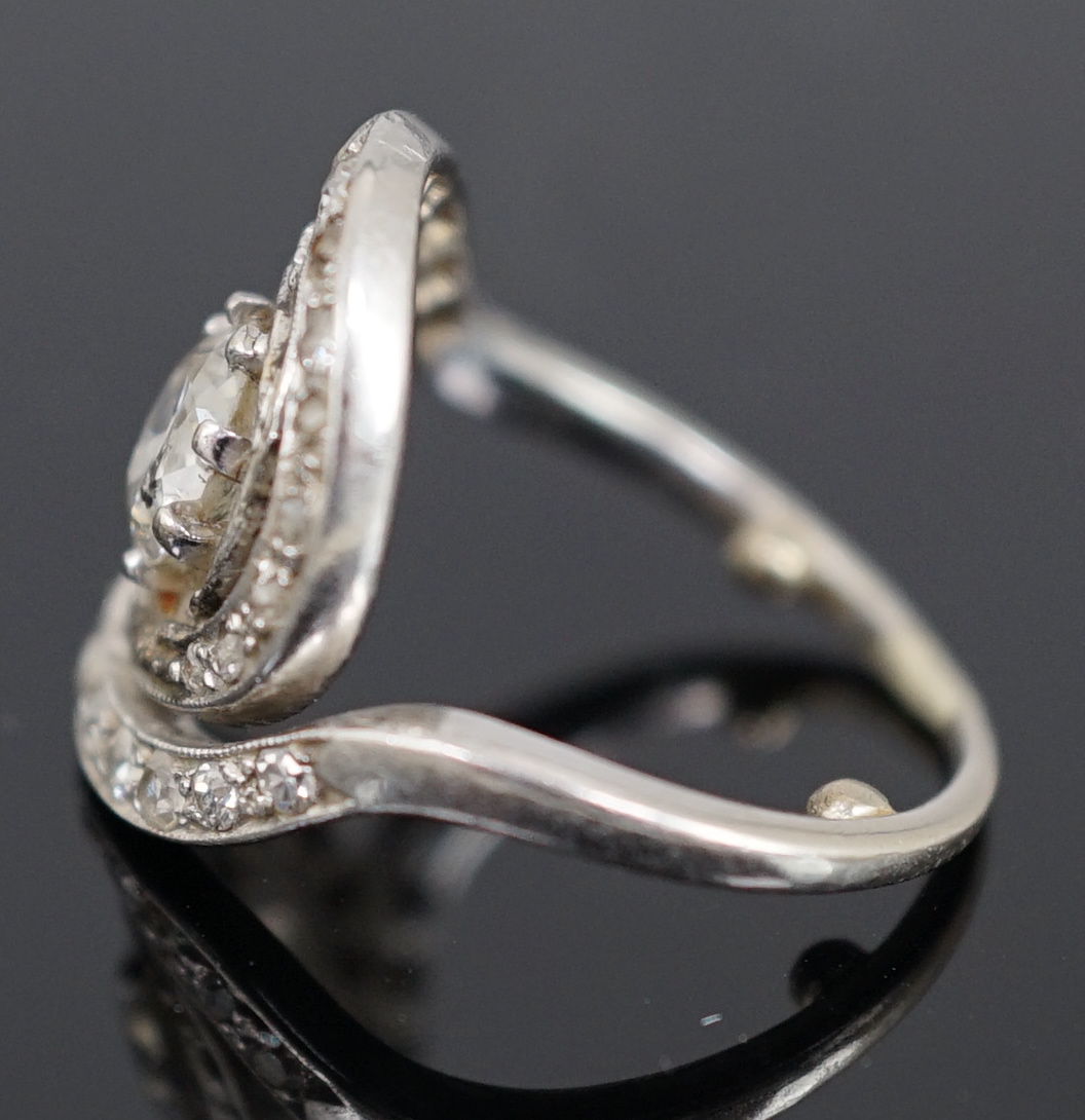 A mid 20th century platinum and diamond cluster set ring, of spiralling design